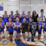 Alameda Post - the St. Joseph Notre Dame girls volleyball team poses together and hold a plaque that says "North Coast Section Championships," and several other words too small to read. They also hold a flag that says "Girls Volleyball NCS 2024 DIV 3 First"