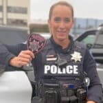 Alameda Police - an Alameda Police Officer holds up a pink APD breast cancer awareness patch