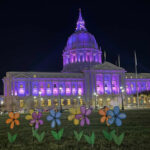 Alameda Post - San Francisco City Hall lit up in purple with flowers in front