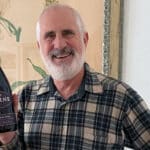 Alameda Post - Randy Arnold holds up a bottle of wine