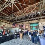 Alameda Post - inside Faction Brewing, attendees of the Home Electrification Fair mill around and visit booths