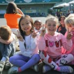 Alameda Post - kids on an outdoor play area flash peace signs to the camera