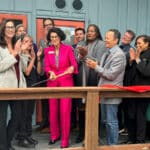 Alameda Post - Mayor Ashcraft cuts a ribbon at Dignity Village, surrounded by smiling and clapping people