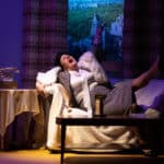 Alameda Post - an actor lays back on a couch and sings dramatically