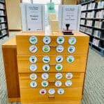 Alameda Post - a cabinet with seeds at the Alameda Main Library. It's covered in signs with the names and photos of produce