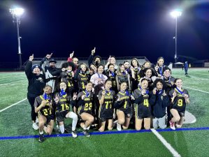 Alameda Post - the AHS Flag Football tag poses for a group photo with a plaque and raises one finger in the air to indicate they are number one