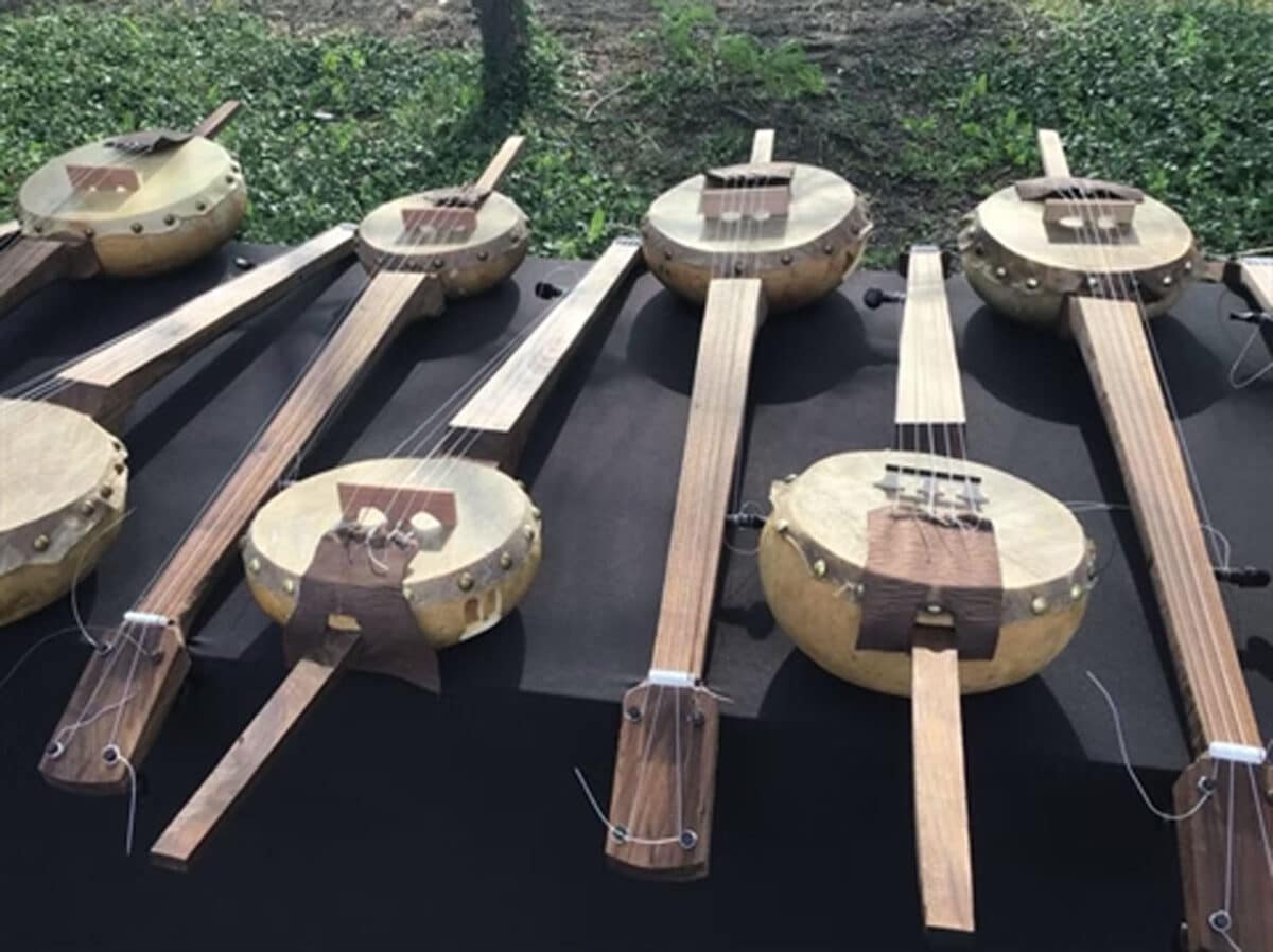 Alameda Post - Eight banjos laid out on a table. 