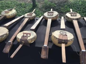 Alameda Post - Eight banjos laid out on a table.