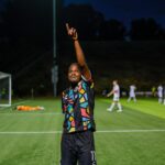 Alameda Post - an Oakland Roots player smiles and holds up the number "1" in a match against Loudoun United