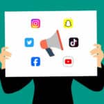 Alameda Post - Social media influencer. An illustration of a person holding a sign with a megaphone surrounded by social media network logos.