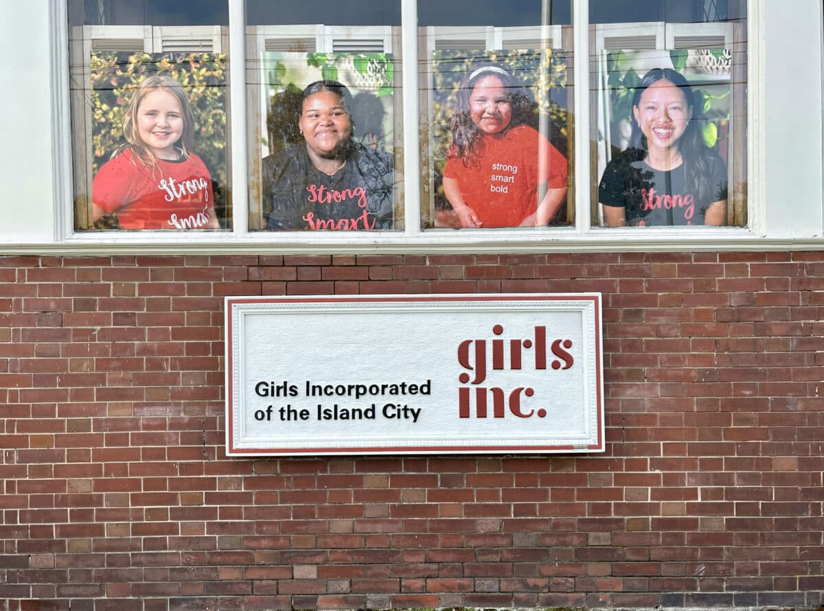 Alameda Post - The side of the Greenleaf House with the Girls Inc sign and photos of young girls who have participated in the windows.