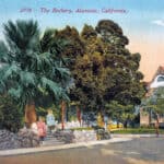Alameda Post - an old color drawing of The Rockery. Children play and explore in a small triangular park with stone walls, grass, and trees