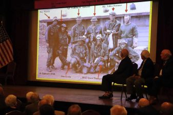 Alameda Post - Onstage at the Alameda Elks Lodge, a slideshow shows an old photo of servicemembers from the Vietnam War.