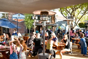 Alameda Post - lots of people sit outdoors at picnic tables at Park Station